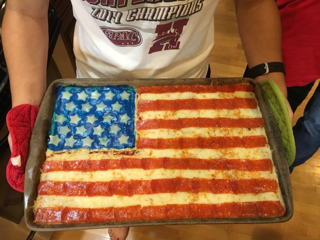 patriotic pizza - pizza with American flag on it.  Stripes are made of cut pepperoni.  Stars are made of cheese.