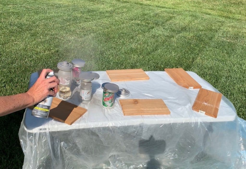 in the process of spray painting the lids for the Dollar Tree Bathroom organization idea, DIY project making cotton ball and cotton swab containers
