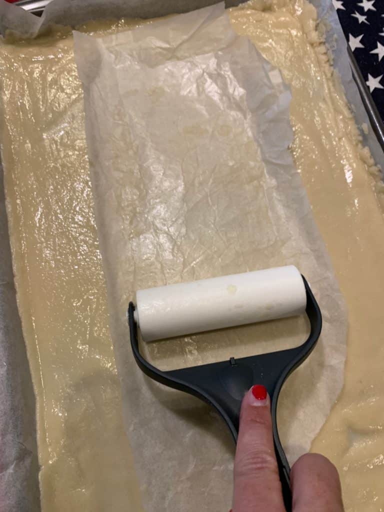 Rolling sugar cookie dough for the flag fruit pizza