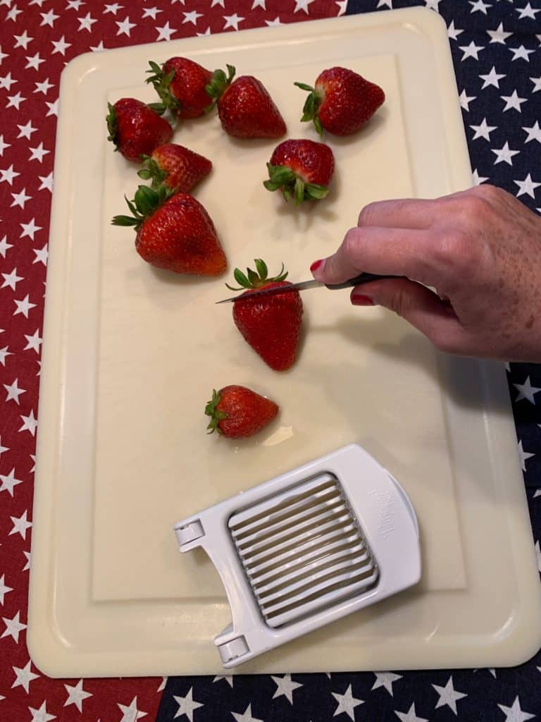 Slicing strawberries for flag fruit pizza