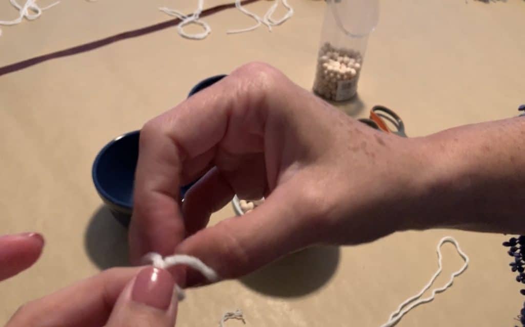 tying knot on strand of yarn