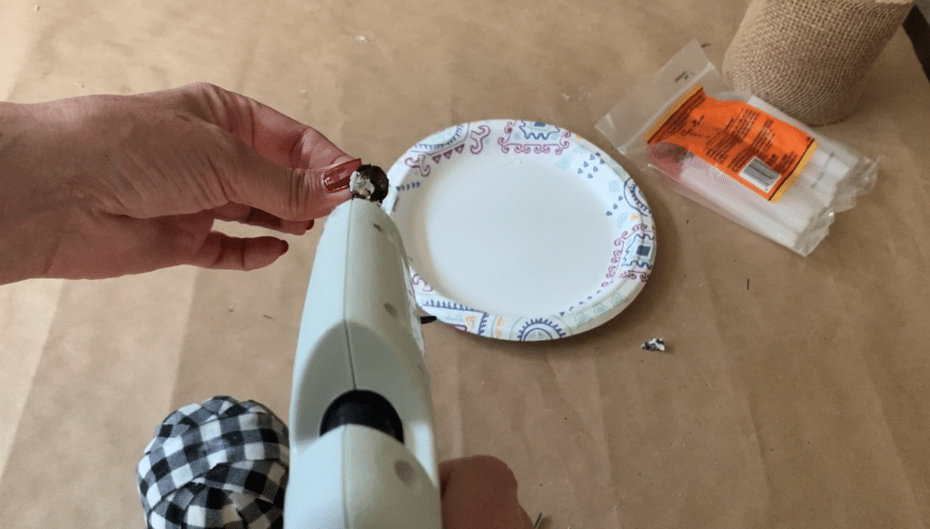 Gluing pumpkin stem back onto fabric covered foam pumpkin for this Halloween decoration DIY project