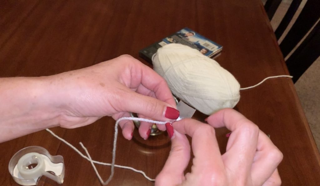 Scotch tape on end of yarn to thread beads
