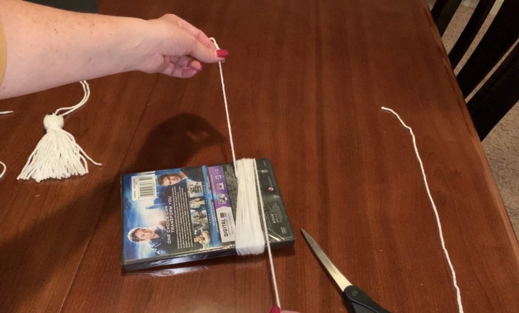 Wrapping yarn around template to make a yarn tassel