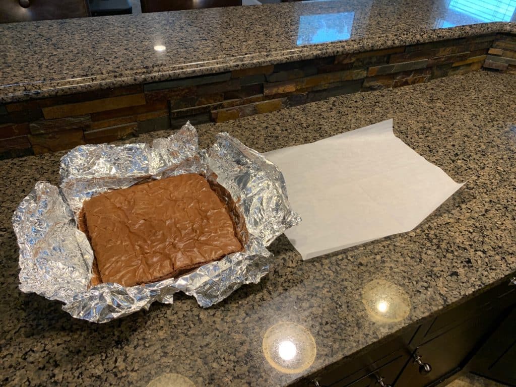 brownie in pan with aluminum foil in pan