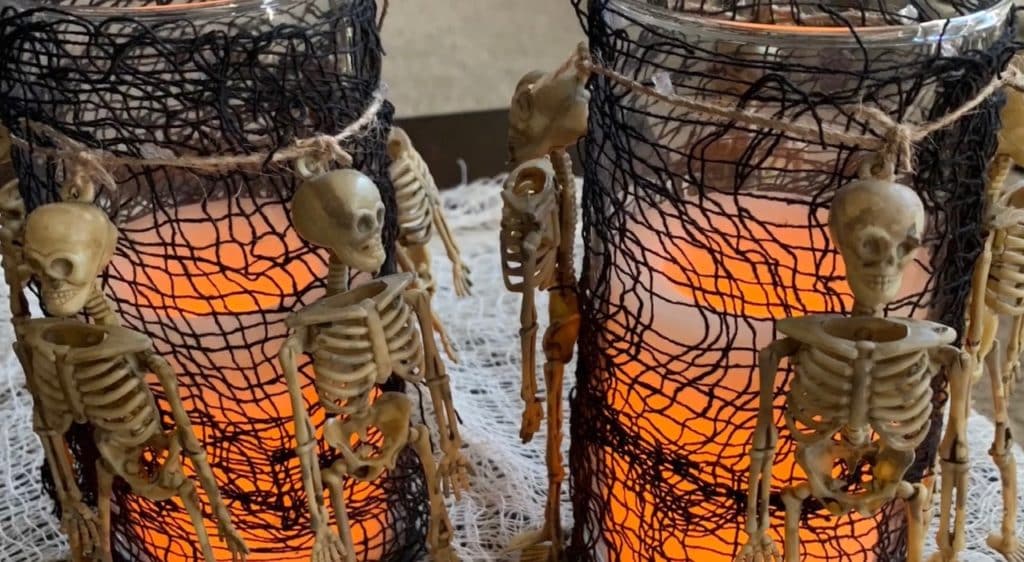 Halloween Decorations DIY: Dollar Tree Skeletons tied onto black mesh covered vase with candle