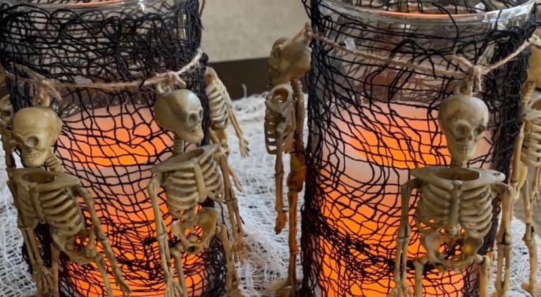Halloween Decorations DIY: Dollar Tree Skeletons tied onto black mesh covered vase with candle