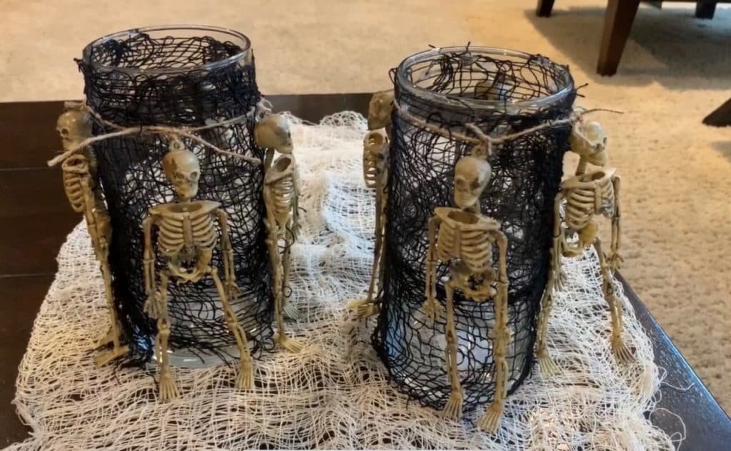 Halloween Decorations DIY: Dollar Tree Skeletons tied onto black mesh covered vase with candle