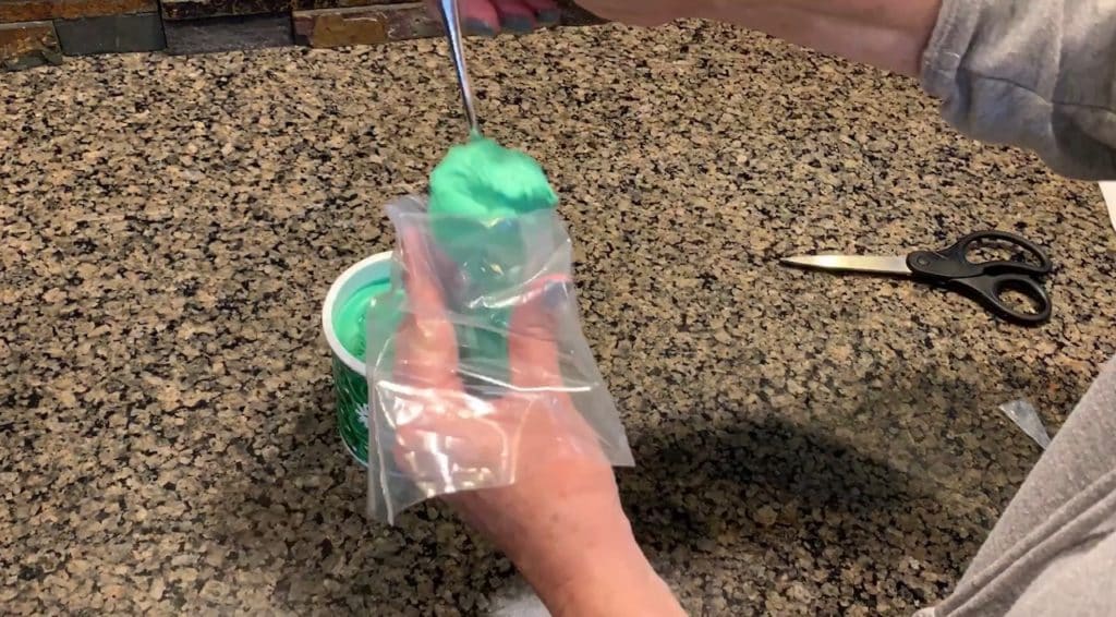 filling up decorating bag with green icing
