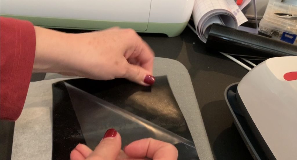 iron everyday heat transfer material onto the back of a cork sheet with a Cricut Easy Press