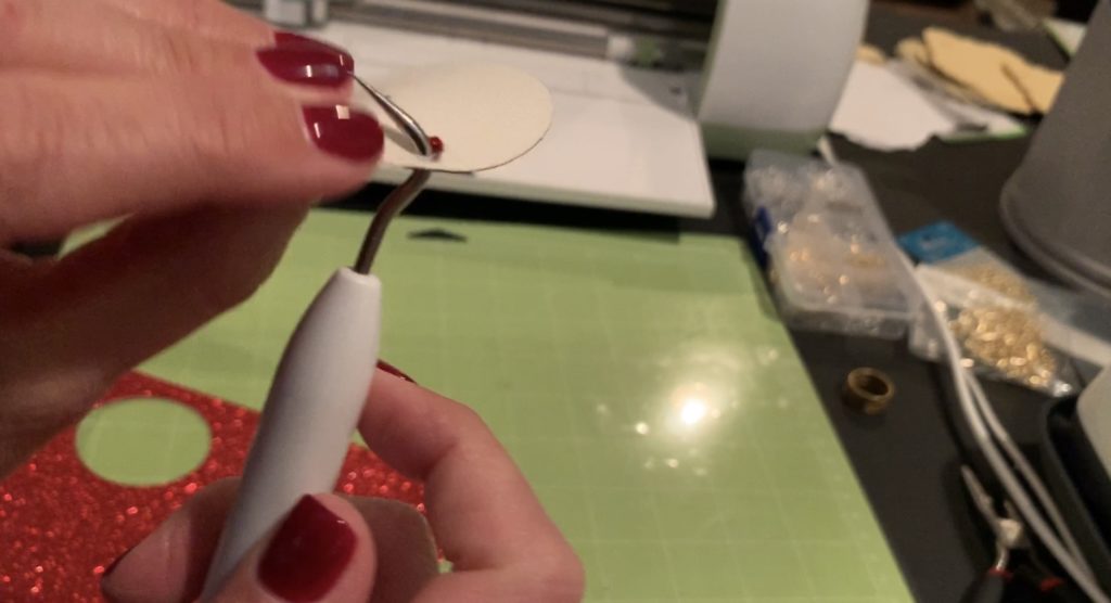 Using Cricut Weeder to poke hole out of the earring shape