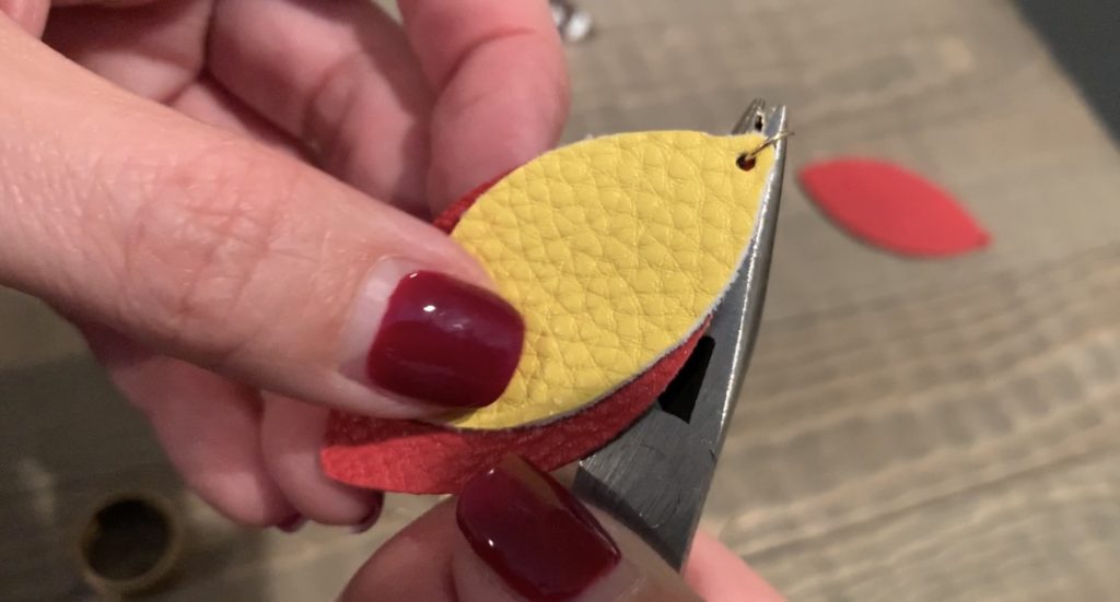 putting football faux leather earrings onto jump rings