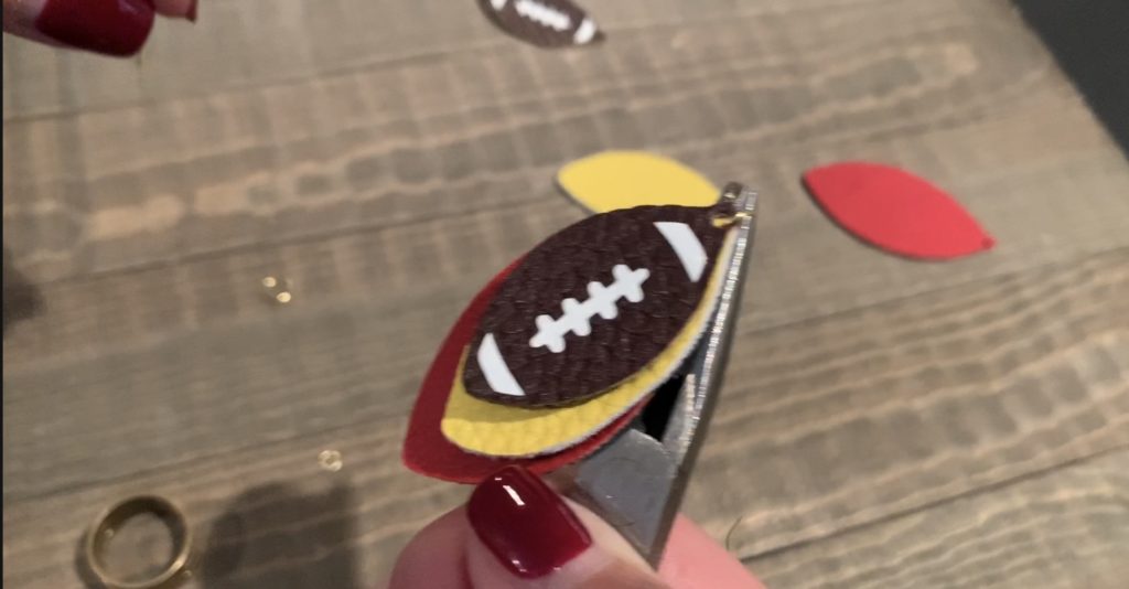 putting football faux leather earrings onto jump rings