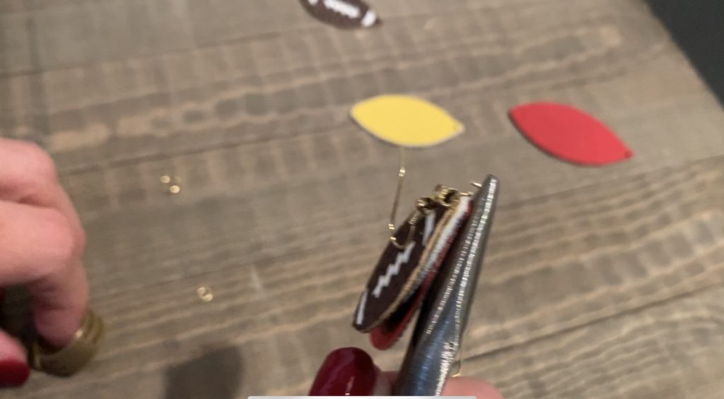 putting football faux leather earrings onto jump rings
