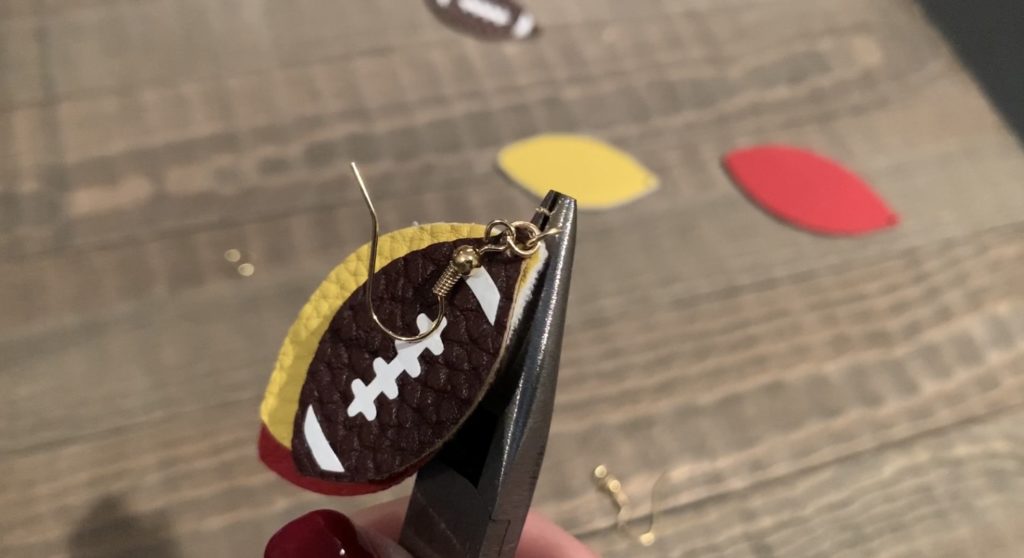 putting football faux leather earrings onto jump rings