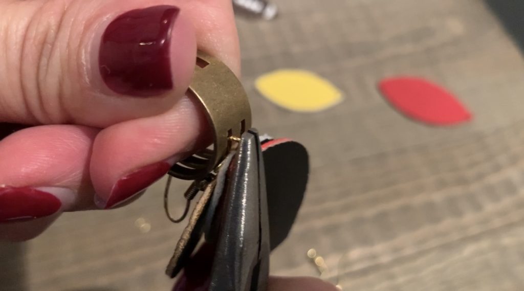putting football faux leather earrings onto jump rings