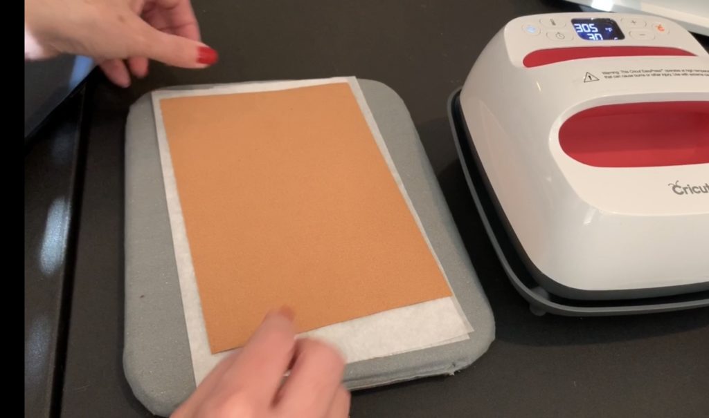 applying heat transfer vinyl (HTV) to the back of a sheet of cork  to make diy tree earrings