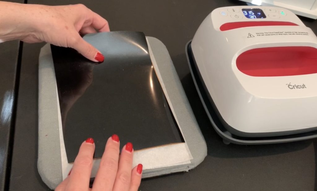 applying heat transfer vinyl (HTV) to the back of a sheet of cork to make diy tree earrings