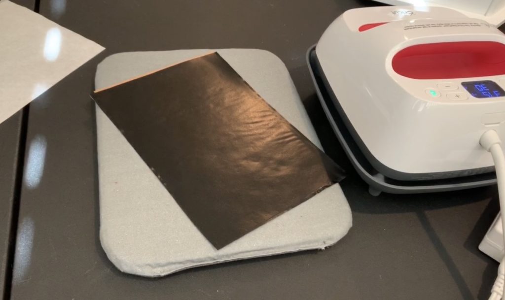 applying heat transfer vinyl (HTV) to the back of a sheet of cork  to make diy tree earrings