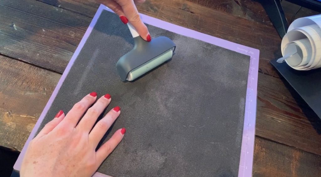 using a Cricut brayer to roll genuine leather onto the Cricut mat
