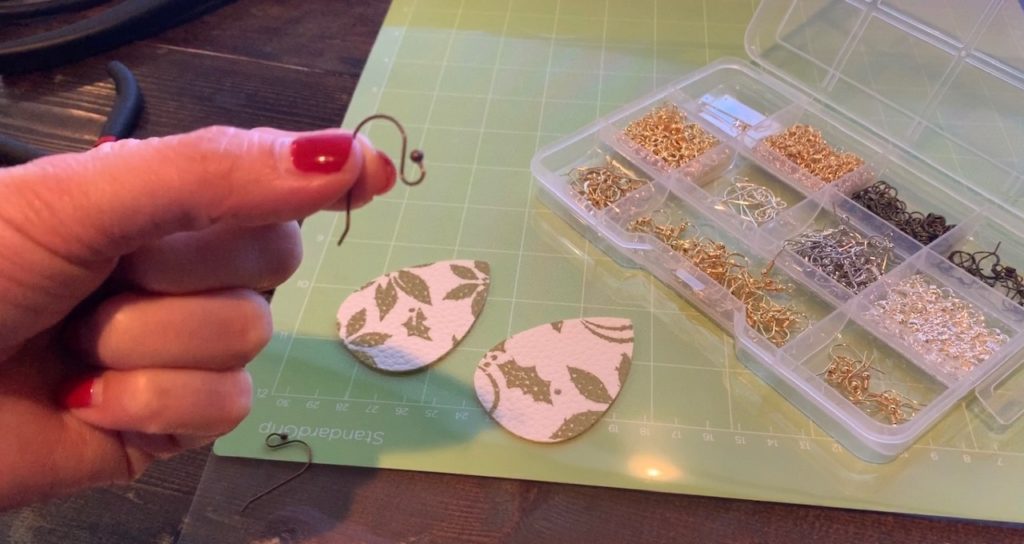 holding earring hook, ready to put the faux leather statement earring on