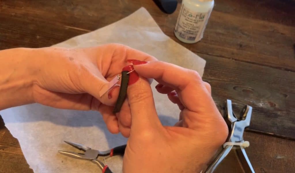 Adding the leather bar earring to the book behind the metal charm