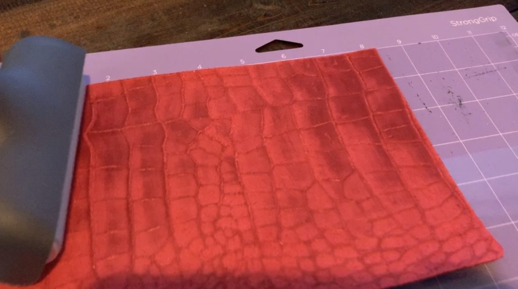 roll the Cricut brayer across the leather to press nicely onto the mat