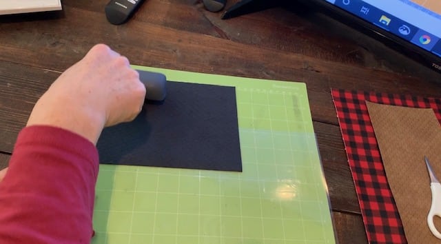 using brayer to press the faux leather onto the mat for this diy jewelry project