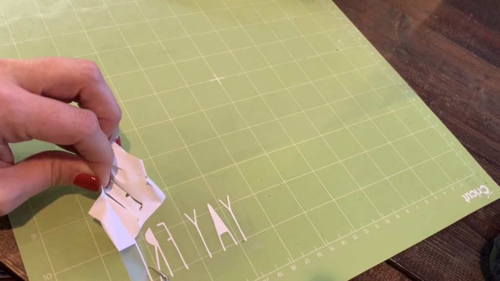 weeding heat transfer vinyl (HTV) with a Cricut weeder so that it can be ironed onto diy earrings
