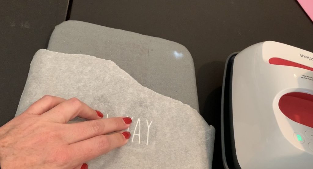 Cover the leather earrings with parchment paper before putting the Cricut easy press on