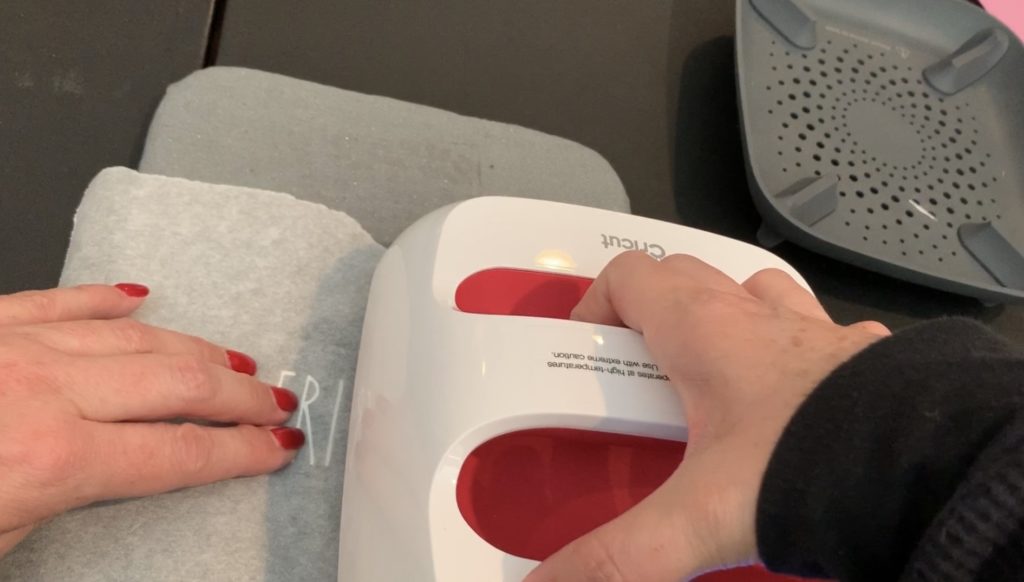 Cover the leather earrings with parchment paper before putting the Cricut easy press on