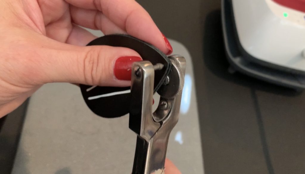 punching hole into the leather teardrop diy earrings