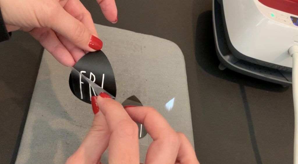 Taking off the heat transfer vinyl backing after applying heat