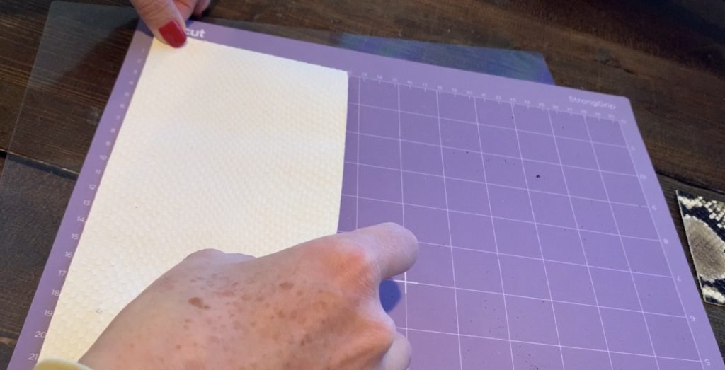 placing leather onto Cricut strong grip mat, good side facing down