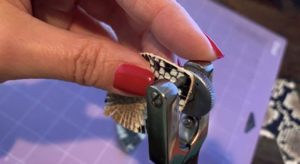 placing a hole punch in a diy leather earring with a leather hole puncher