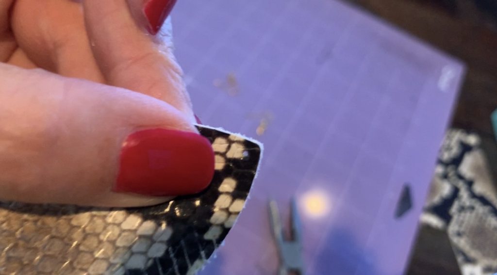 placing a hole punch in a diy leather earring with a leather hole puncher