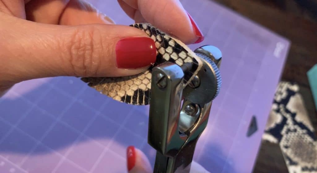 placing a hole punch in a diy leather earring with a leather hole puncher