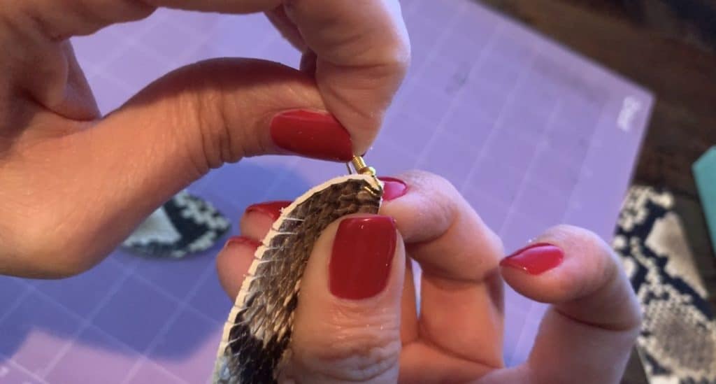 putting the leather earring onto the earring hook