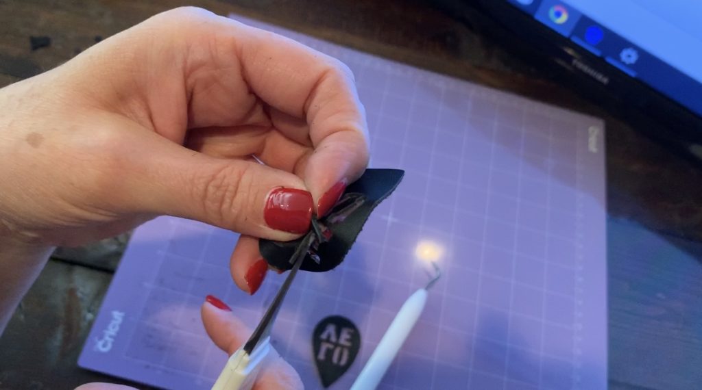 snip off the pieces of the leather earring that didn't cut on the Cricut machine for this diy earrings project