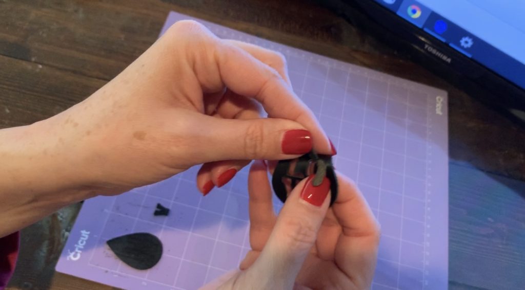 snip off the pieces of the leather earring that didn't cut on the Cricut machine for this diy earrings project
