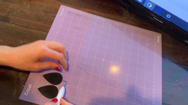 LOVE leather earrings still on the mat after being cut on Cricut