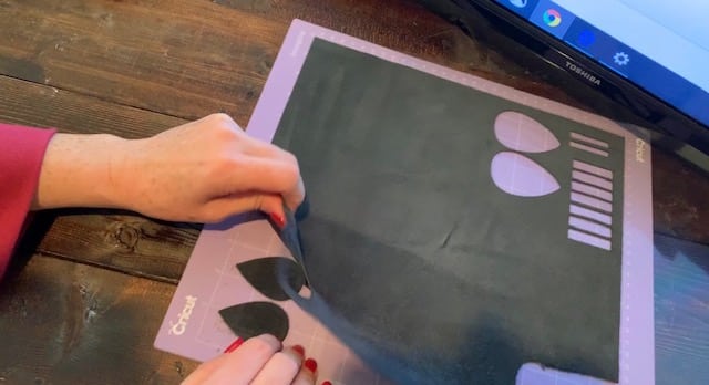 LOVE leather earrings still on the mat after being cut on Cricut