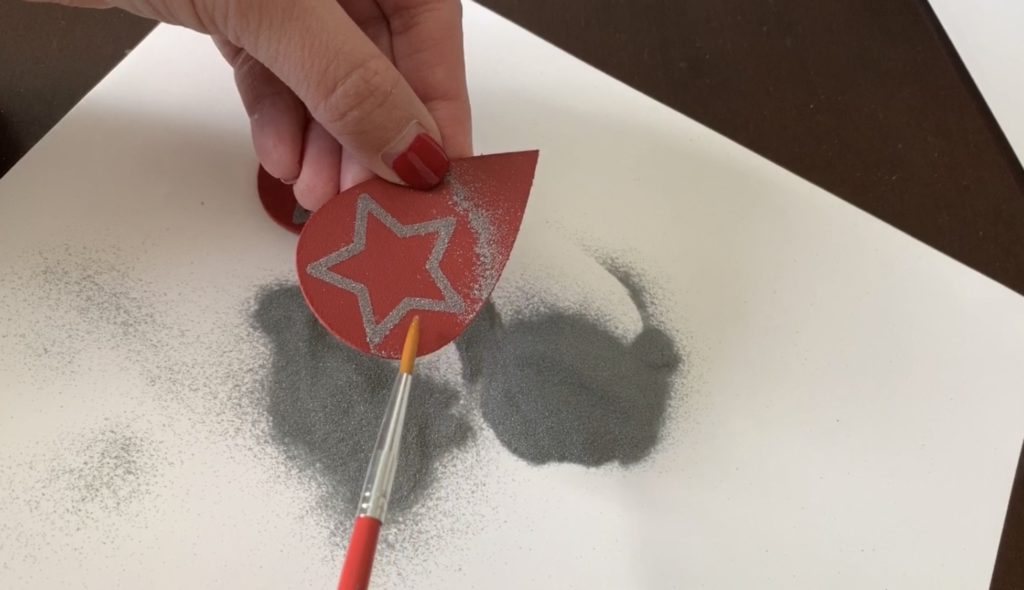 Use a brush to remove excess embossing powder from the earring