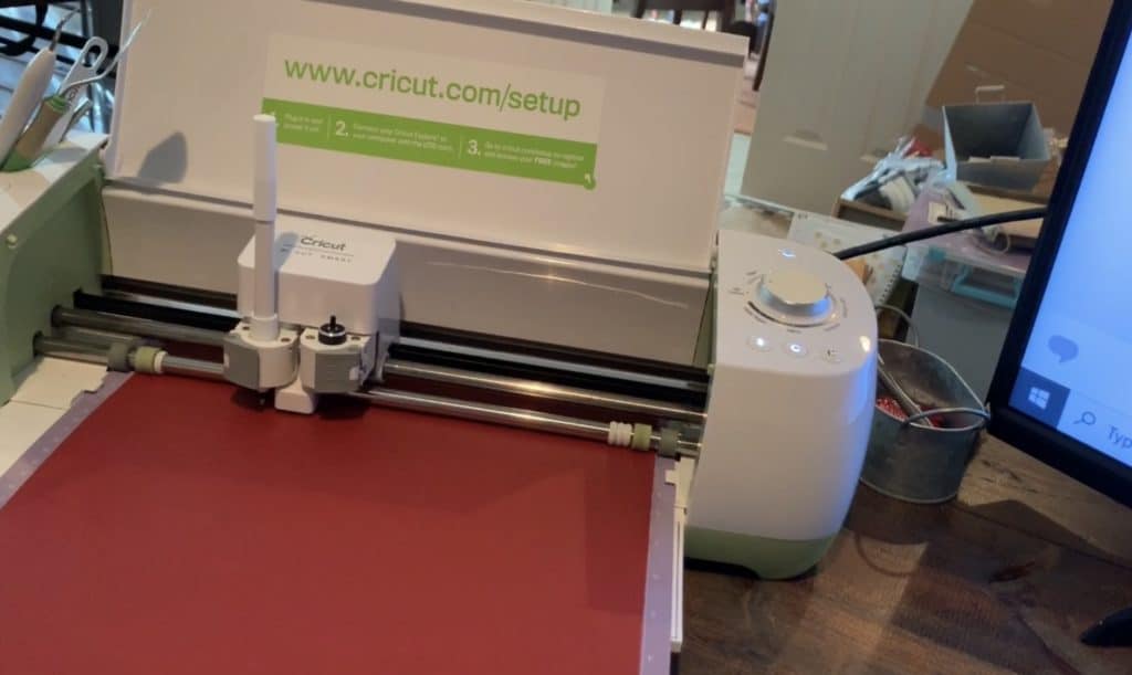 Embossing pen in Cricut machine drawing shape onto leather earring