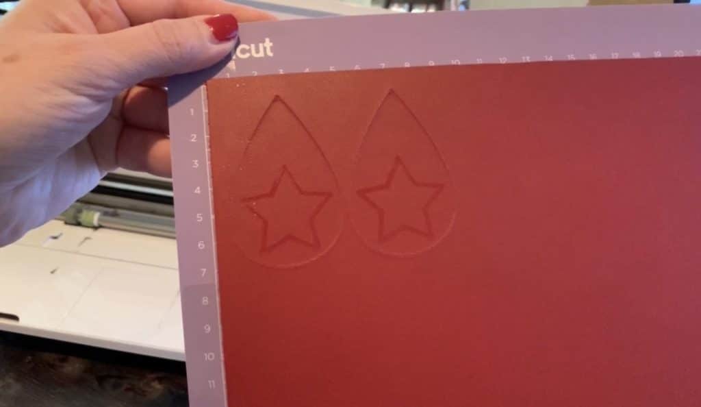 leather earrings cut but still on the Cricut Mat with embossing ink visible