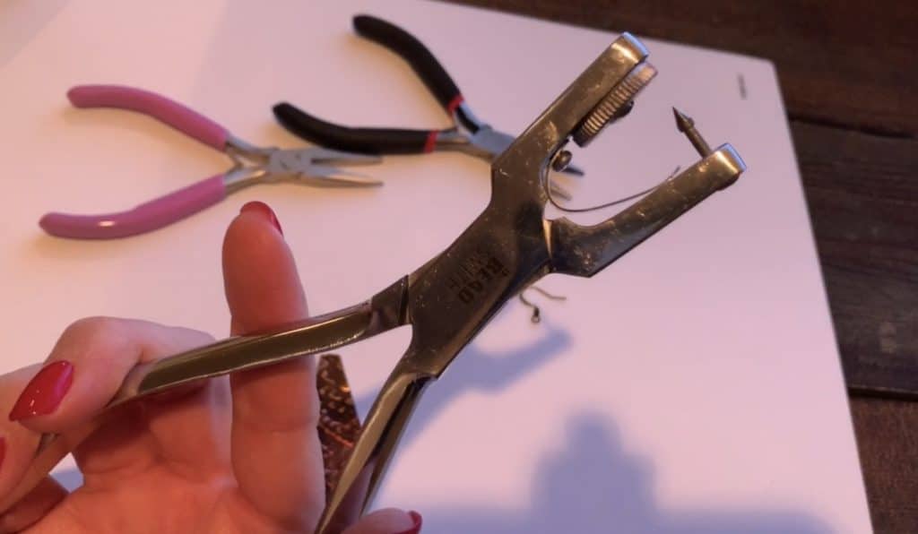 use leather hole punch to punch hole in diy faux leather earrings and diy leather earrings