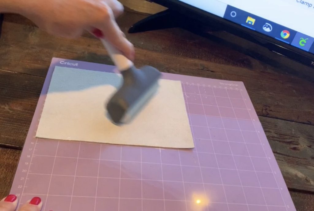 Using a Cricut brayer to make sure leather was firmly pressed upon the Cricut mat