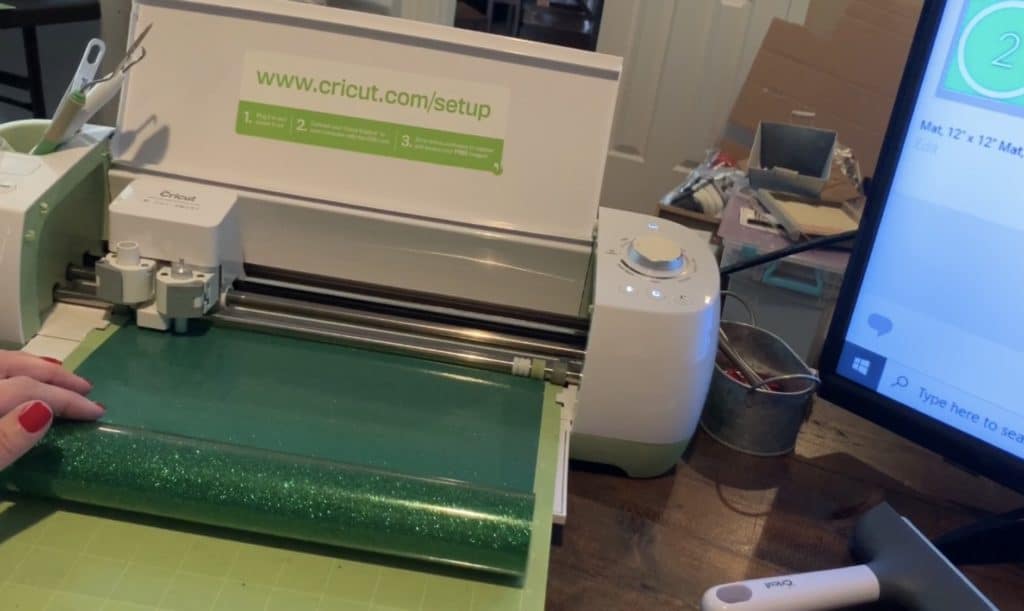 cutting the green glitter heat transfer vinyl on the Cricut machine