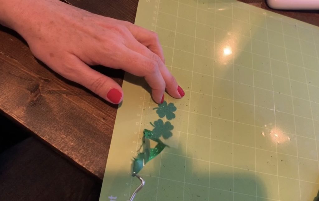 weeding green glitter heat transfer vinyl on the standard grip Cricut mat