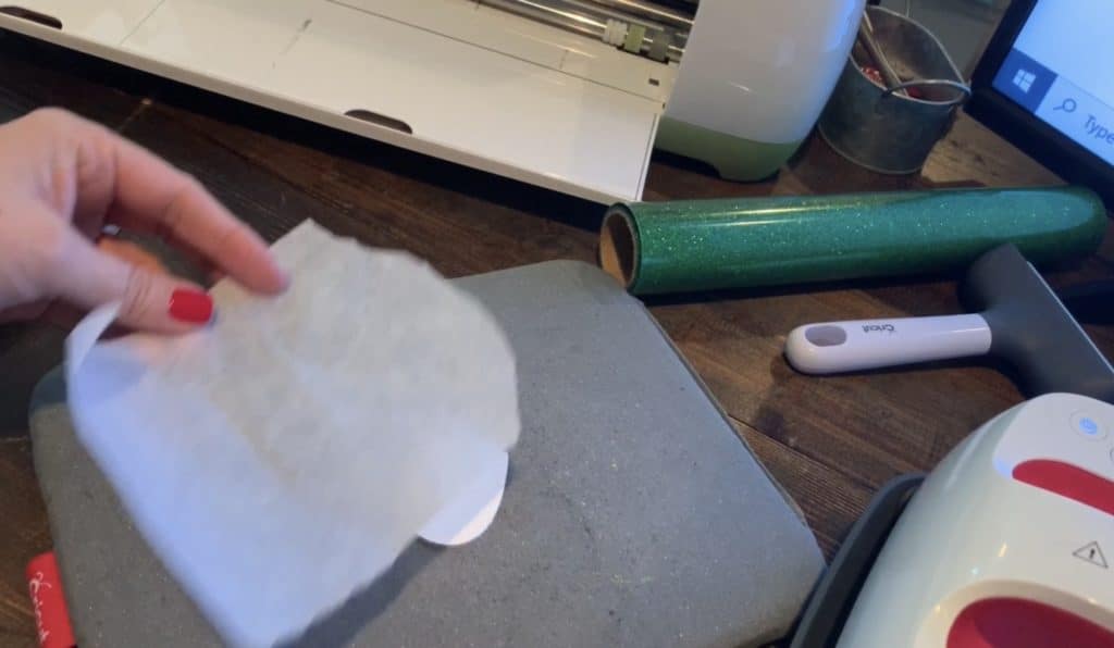 placing parchment paper on top of leather before placing the Cricut Easy Press on it